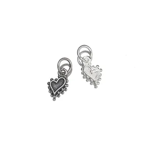 Gros plan détaillé de breloques cœur en argent sterling 925, finitions vintage et claire