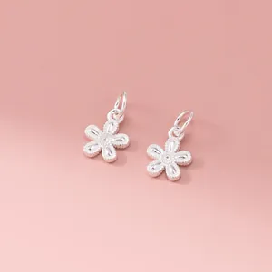 Detailed view of two 925 sterling silver Thai silver flower pendants for DIY jewelry.