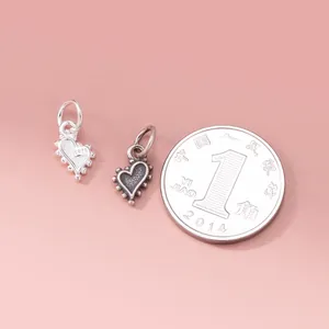 Vue détaillée de breloques en argent sterling 925 en forme de cœur avec une pièce de monnaie