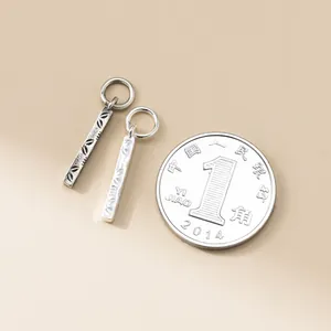 Nahaufnahme von 925 Sterling Silber Vintage Bar Anhängern mit Münze als Größenreferenz.