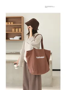 Minimalist Japanese style brown linen tote bag with Salomé print shown on a model
