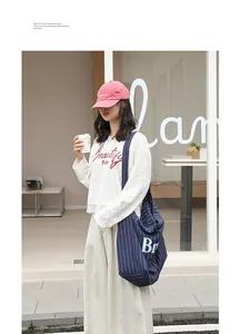 Fashionable striped cotton linen tote bag with letter print shown in a street lifestyle scene