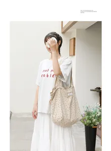 Bolso tote japonés de lona beige con lunares y cordón ajustable mostrado en modelo