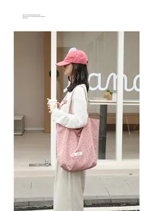 Asian model carrying a pink polka dot nylon tote bag in a casual street setting.