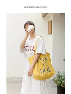 Modello con una borsa tote in tela gialla con stampa di lettere blu casual