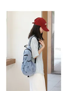 Lifestyle view of a casual light blue pleated nylon backpack with drawstring details