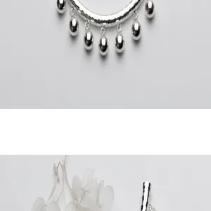 Dettaglio di un tubo martellato in argento sterling S925 con ciondoli a campana lisci