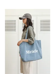Vista de detalle del bolso tote japonés a cuadros azules con estampado Miracle