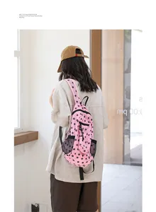 Vista trasera de mujer con mochila de nailon rosa con lunares en un entorno interior luminoso