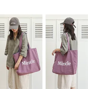 Bolso tote de nylon a cuadros morados con estampado Miracle mostrado en una modelo