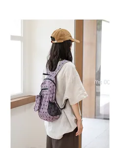 Mochila ligera de nailon con lunares morados para mujer, vista trasera en modelo