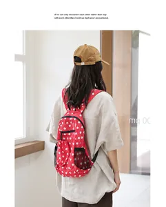 Elegante mochila de nailon roja con lunares blancos para mujer en un entorno informal