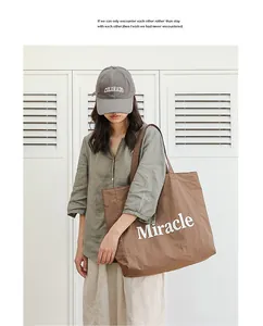 Bolso tote informal de nailon marrón con estampado de Miracle mostrado en una modelo