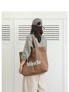 Bolso tote informal de nailon marrón con estampado Miracle llevado por una modelo
