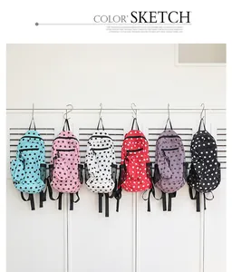 Colección de mochilas de lona con lunares en varios colores colgadas de ganchos de metal