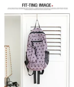 Vista detallada de una mochila de nailon con lunares morados, textura de rejilla y bolso