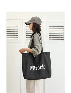 Bolso tote a cuadros blancos y negros con estampado Miracle llevado por modelo