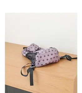 Detalle de la mochila de nailon con lunares morados, malla negra y correas