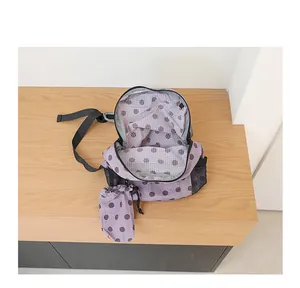 Vista detallada de la mochila de nailon morada con lunares y una pequeña bolsa a juego