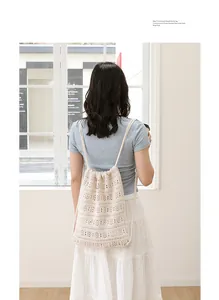 Vista trasera de una persona con una mochila de punto calado en color crema de estilo casual