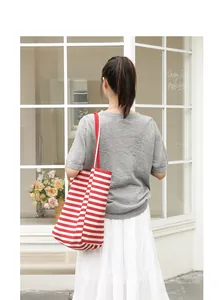 Casual red and white striped tote bag shown in a stylish outdoor lifestyle setting