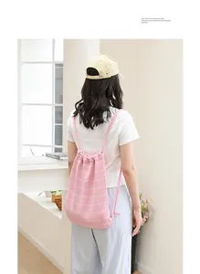Detailansicht eines Modells mit einem rosa gestreiften Strick-Kordelzug-Rucksack aus Baumwolle