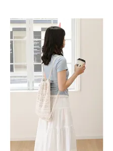 Primer plano de una mochila de ganchillo crema con elegantes motivos calados