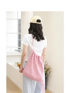 Rückansicht eines pink gestreiften Strickbeutels mit Kordelzug an einem Model getragen.