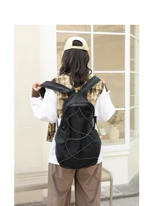 Detalle de la mochila casual de nailon negro con bolsillos de malla y cordón elástico