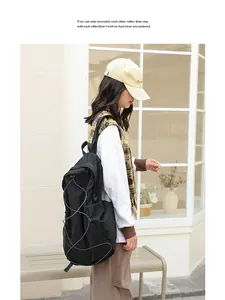 Mochila moderna de nailon negro con bolsillos laterales de malla y cordones elásticos