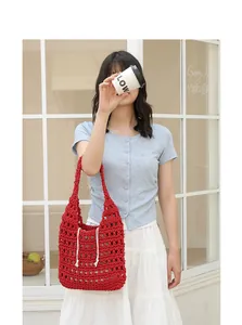 Model holding a stylish red handmade crochet hobo bag in a casual outdoor setting