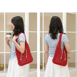 Red handmade crochet underarm bag with white drawstring inner pouch, detailed view