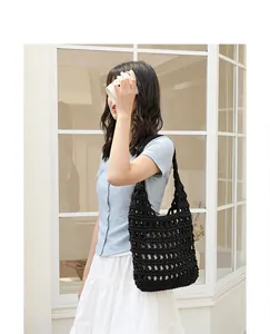 Stylish handmade black crochet shoulder bag with hollow knit design shown on model