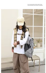 Vista de cuerpo entero de modelo con mochila de nailon gris y bolsillos de malla