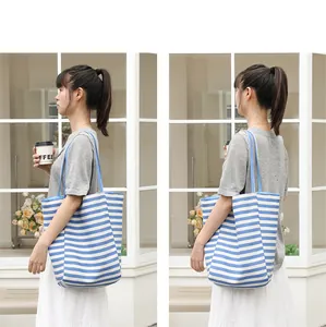 Detailed view of casual blue and white striped canvas tote bag on female model