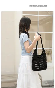 Professional lifestyle shot of a black handmade woven cotton shoulder bag with hollow design