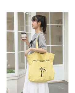 Frau mit gelber Nylon-Tragetasche mit Palmen-Print im lässigen Streetstyle-Look