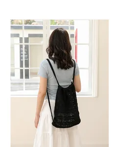 Vista trasera de estilo de vida de mochila tejida negra con elegante diseño calado.