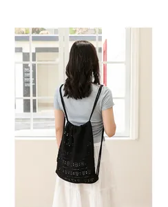 Vista trasera de una mochila negra de algodón trenzado con cordón.