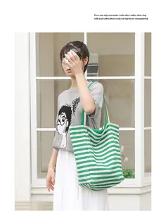Casual green and white striped canvas tote bag shown on an Asian model near a shop window