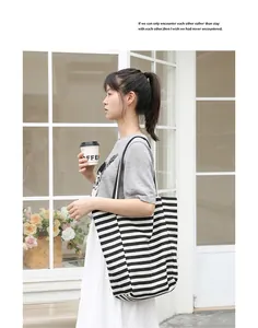 Detailed view of a Japanese style striped canvas tote bag carried by a model