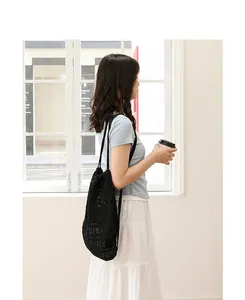 Vista de estilo de vida de una mochila de algodón de ganchillo negro calado