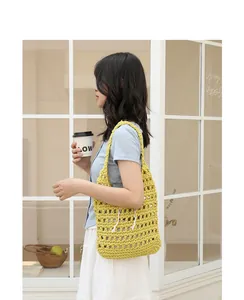 Detail showing the yellow handmade crochet woven shoulder bag on model's shoulder.