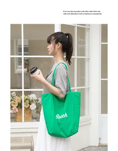 Vista lateral de moda del bolso tote de nailon verde con un gráfico Beach blanco impreso
