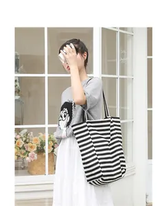 Lifestyle view of a casual Japanese style black and white striped canvas tote bag