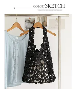 Stylish black floral lace hollow-out shoulder bag with drawstring inner pouch on rack.