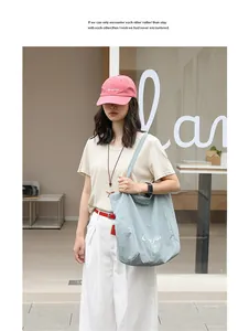 Close-up of a model wearing a casual light blue nylon tote bag in an urban setting