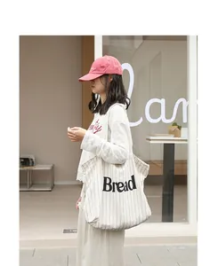 Detail of a striped cotton canvas tote bag with black Bread print for casual outings