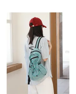 Back view of a woman wearing a casual light blue grid nylon backpack with drawstrings