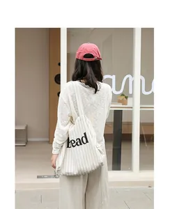 Stylish casual striped canvas tote bag with letter print shown in a bright lifestyle setting.